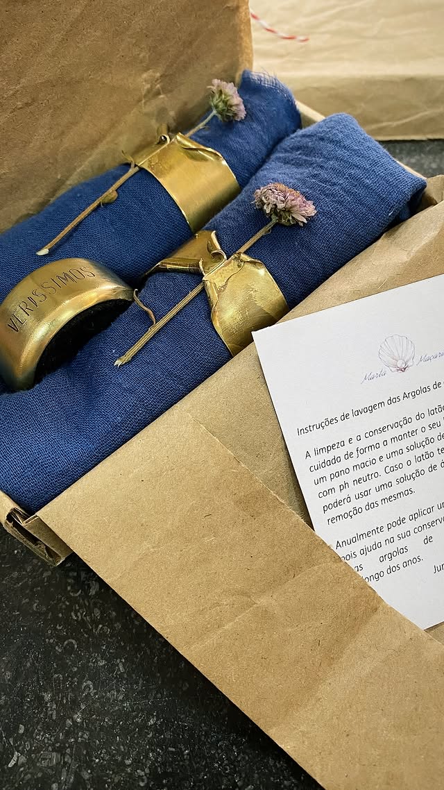 Embalagem em papel kraft com guardanapos azuis, flores secas e cartão de instruções da Marta Maçarico